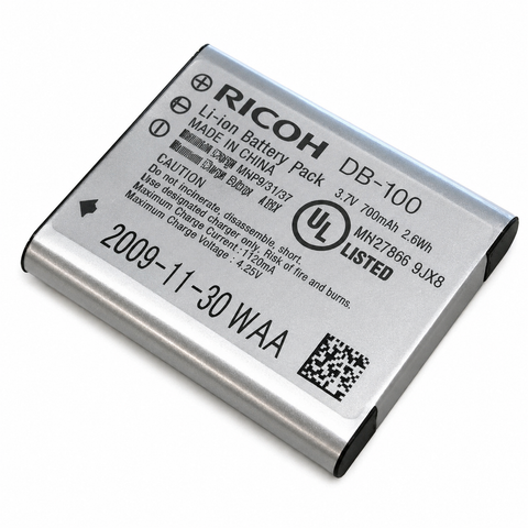 Ricoh accu DB-100, zilver met etiket 3.7V 700mAh en datumstempel, bovenkant
