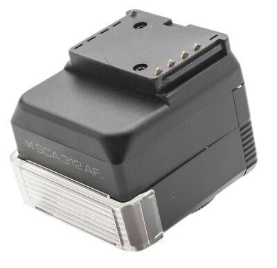 Metz SCA 312 AF flitsadapter voor Canon EOS, zwarte adapter met opschrift SCA 312 AF en doorzichtige onderkant