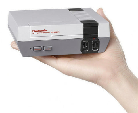 Nintendo Classic Mini NES console zonder controller, grijs, op een open hand gehouden schuin van voren, tweedehands