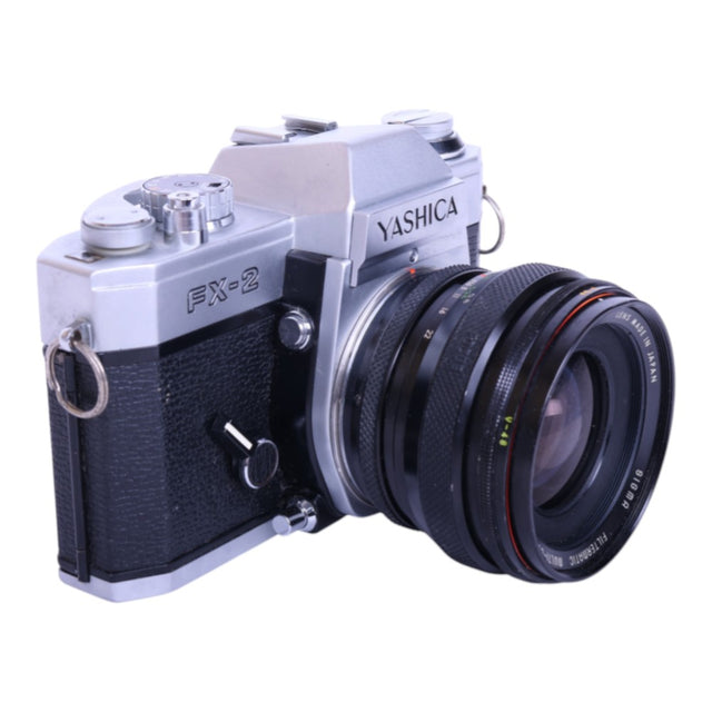 Yashica FX-2 analoge spiegelreflexcamera, zilver/zwart, met Sigma Filtermatic 24mm f/2.8 lens, schuin van voren, tweedehands