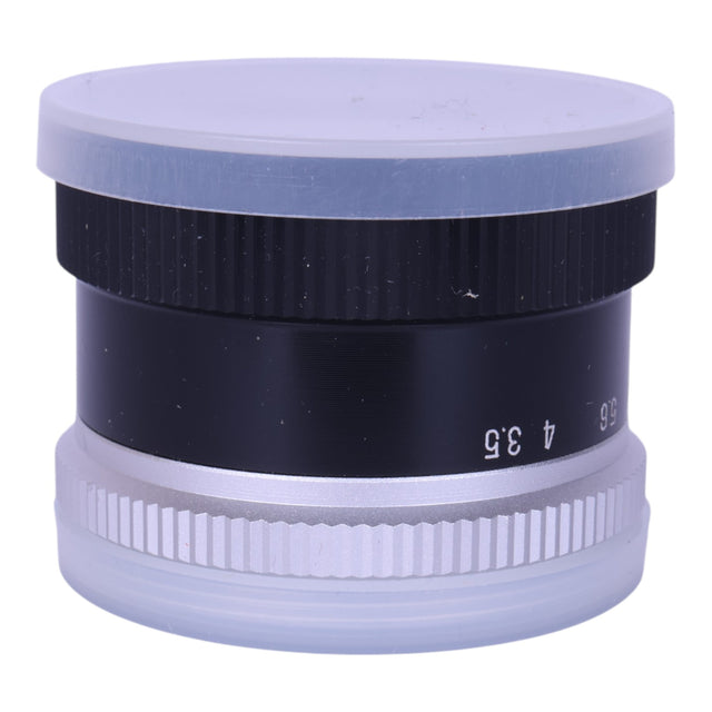 Albinar 75mm f/3.5 vintage vergrotingslens, zijkant met doorzichtige lensdoppen voor en achter, tweedehands