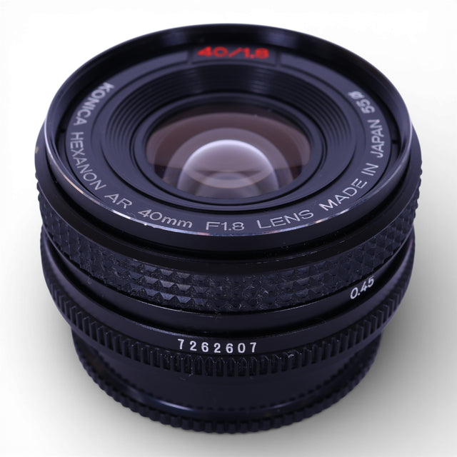 Konica Hexanon AR 40mm f/1.8 pancake-objectief, zwart, schuin van boven met rood opschrift 40/1.8 en serienummer, tweedehands