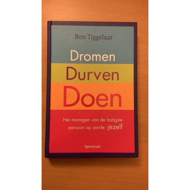 Dromen, durven, doen, Ben Tiggelaar, omslag met grijze, gele, oranje en rode banen, tweedehands
